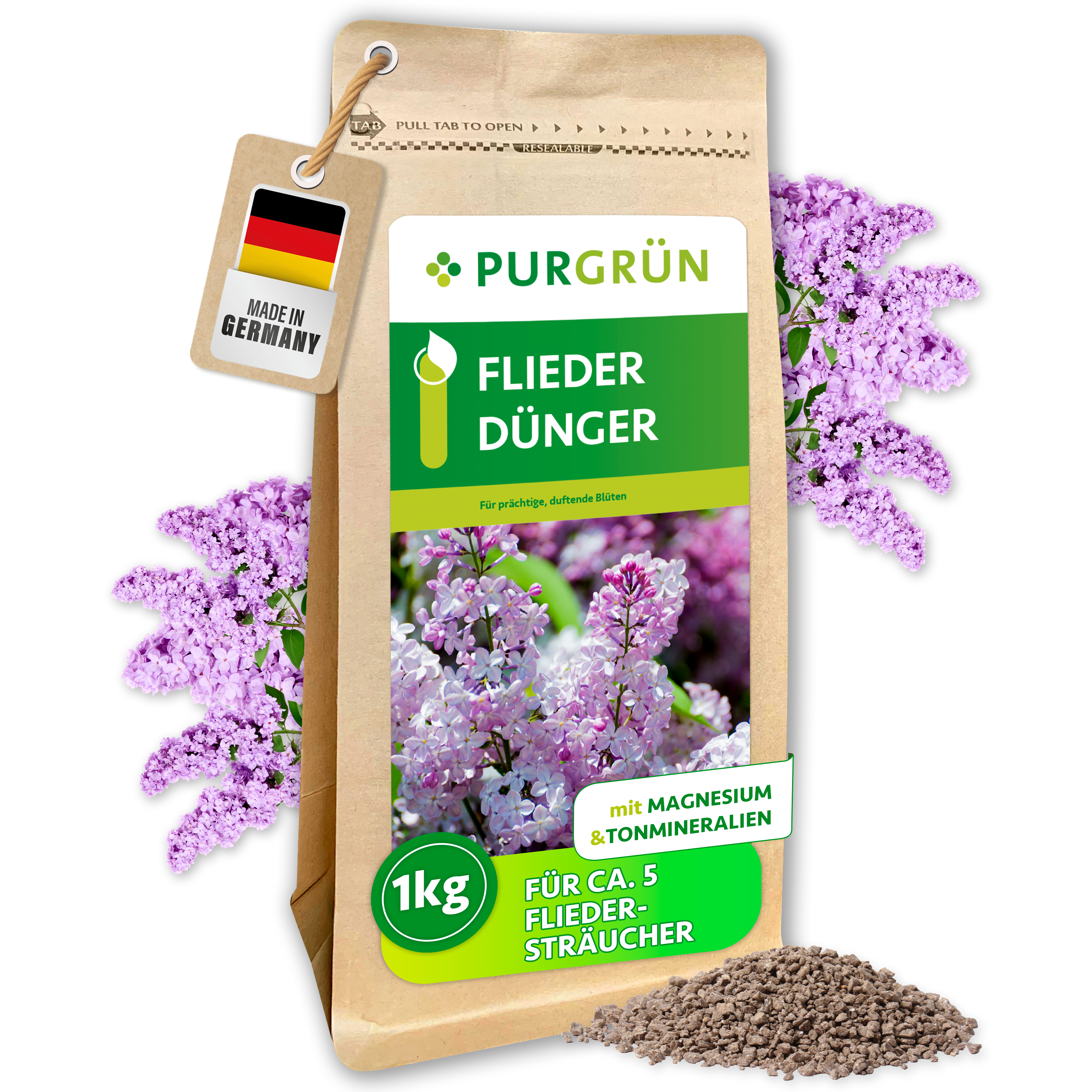 Purgrün Fliederdünger im 1-kg-Papierbeutel, umgeben von Fliederblüten und feinem Granulat; reicht für ca. 5 Fliedersträucher.