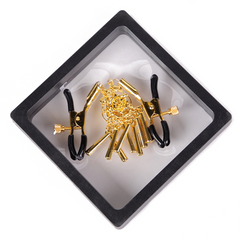 A pair of gold rose chime tassel nipple clamps sits in its clear package.