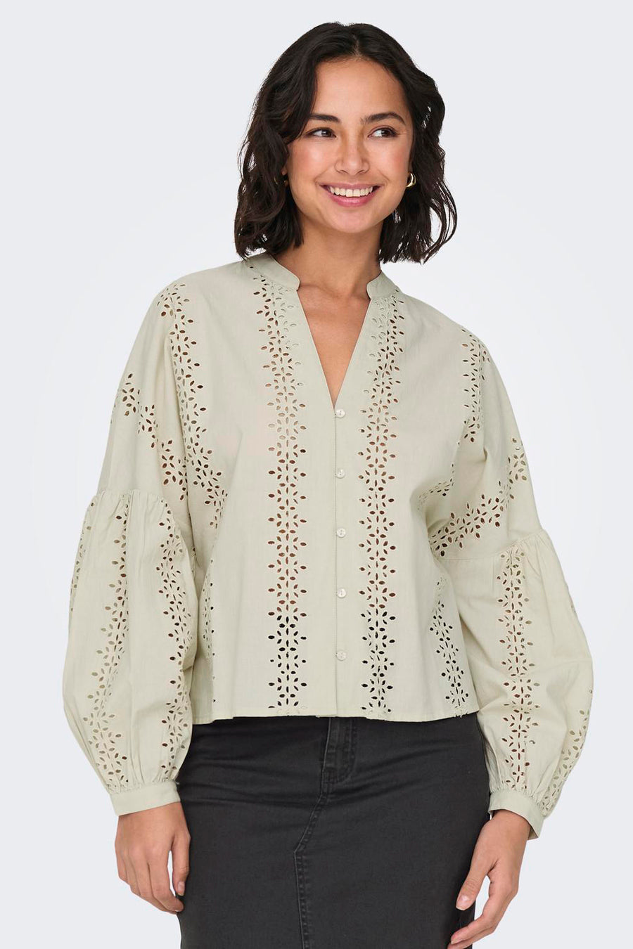 Ecru blouse met lange mouwen van ONLY, met geborduurde details en pofmouwen gecombineerd met een zwarte jeans.
