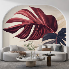 Un salon moderne avec un papier peint tropical représentant de grandes feuilles rouges et bleues sur fond clair, créant une ambiance chaleureuse et accueillante.
